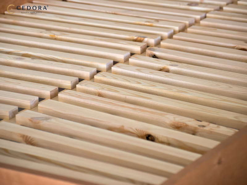 Diagram comparing a curved sprung slat base with a flat solid slat base under a white timber bed frame
