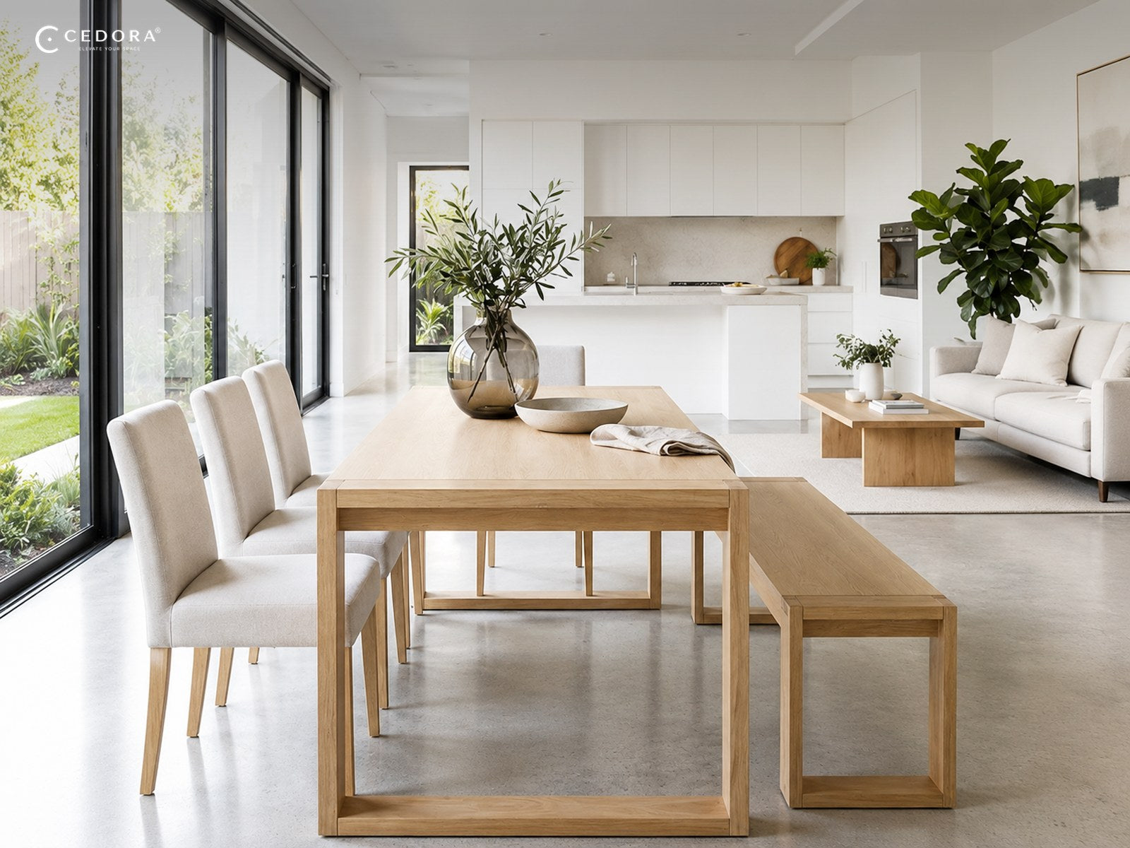 An open plan kitchen and dining space with a light timber dining table and bench beside floor to ceiling windows