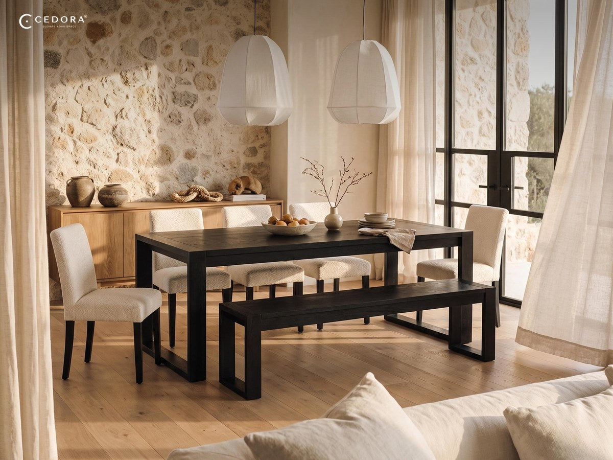 Black timber dining table with a matching bench and cream upholstered chairs on a pale timber floor