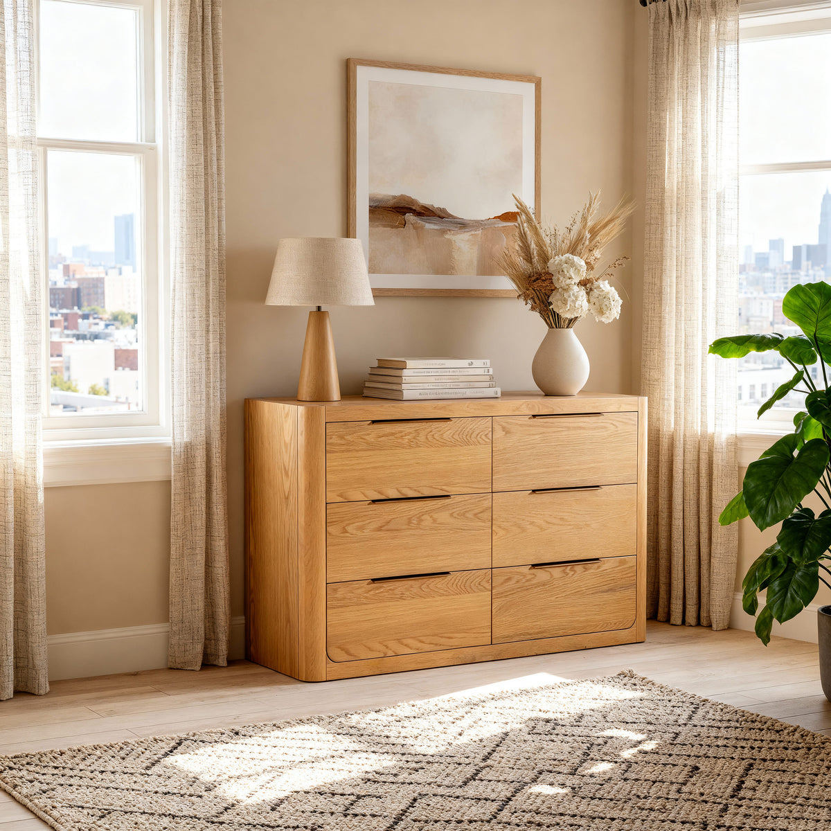 Liverpool Pine 6 Drawer Chest - Natural below framed abstract art, topped with a lamp and a vase of dried blooms