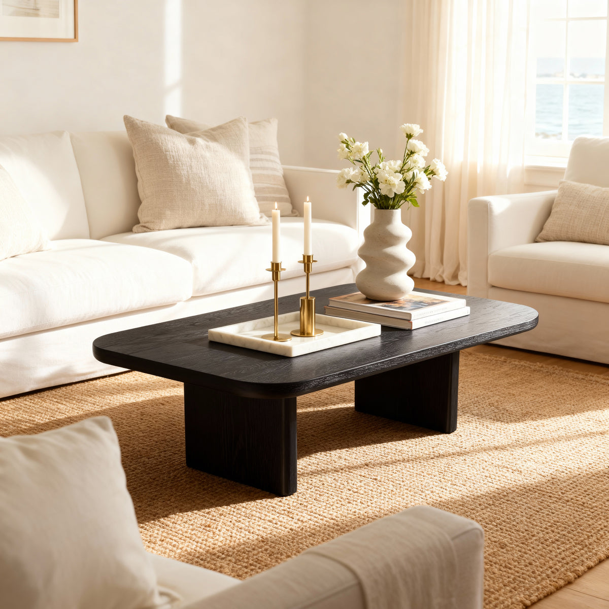 Living room with a black coffee table, white sofa, and decorative items.

