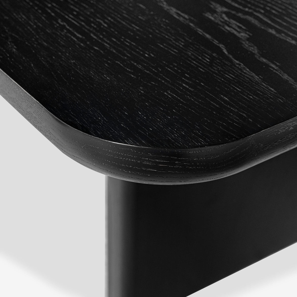 Close-up of a black wooden table corner on a white background

