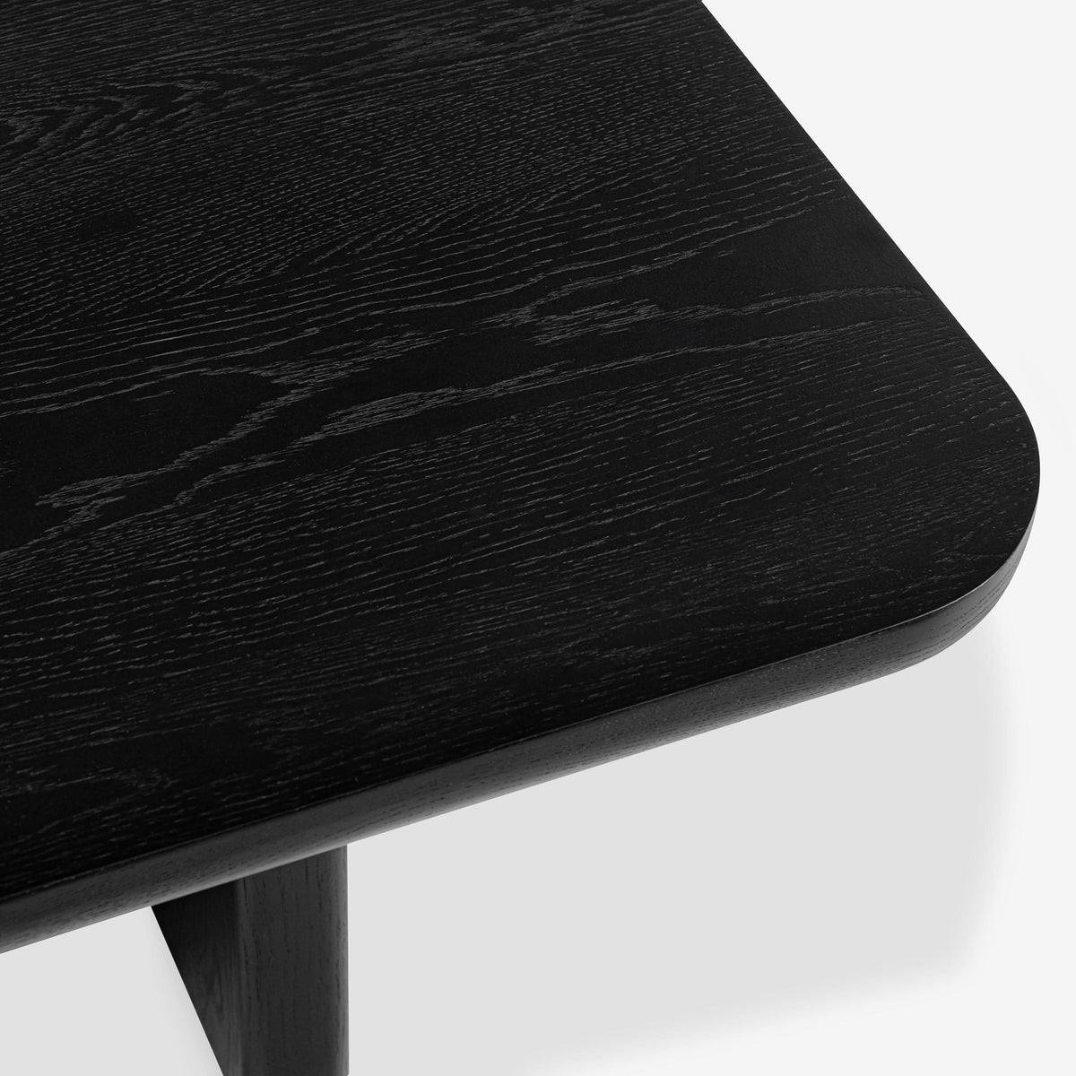 Close-up of a black wooden table corner on a white background

