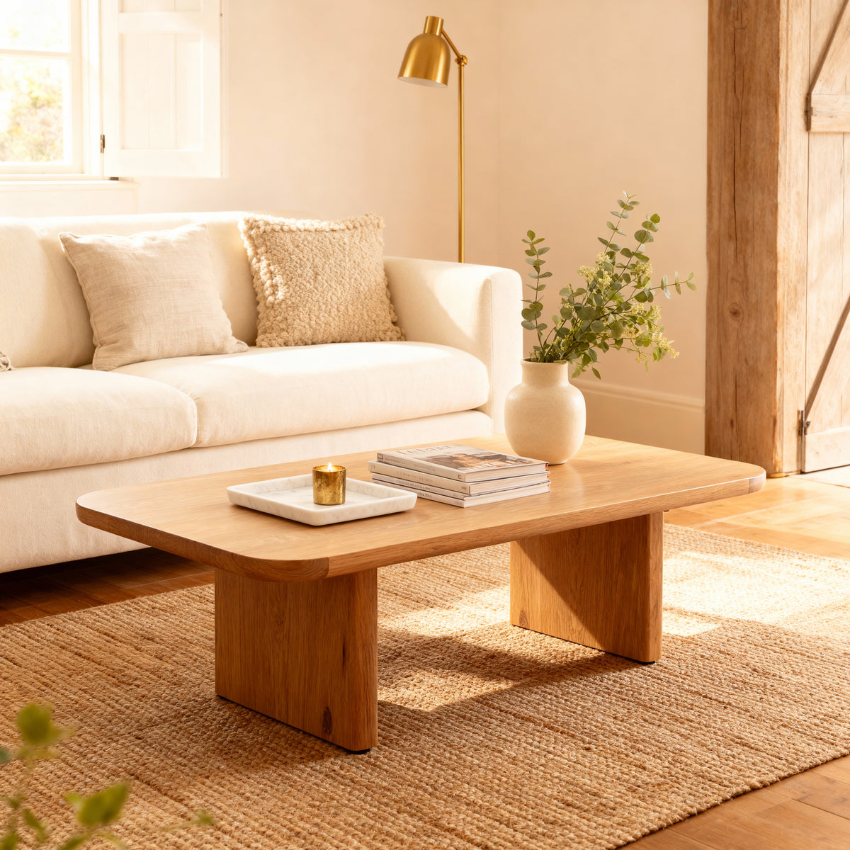 Living room with a wooden coffee table, white sofa, and decorative items.

