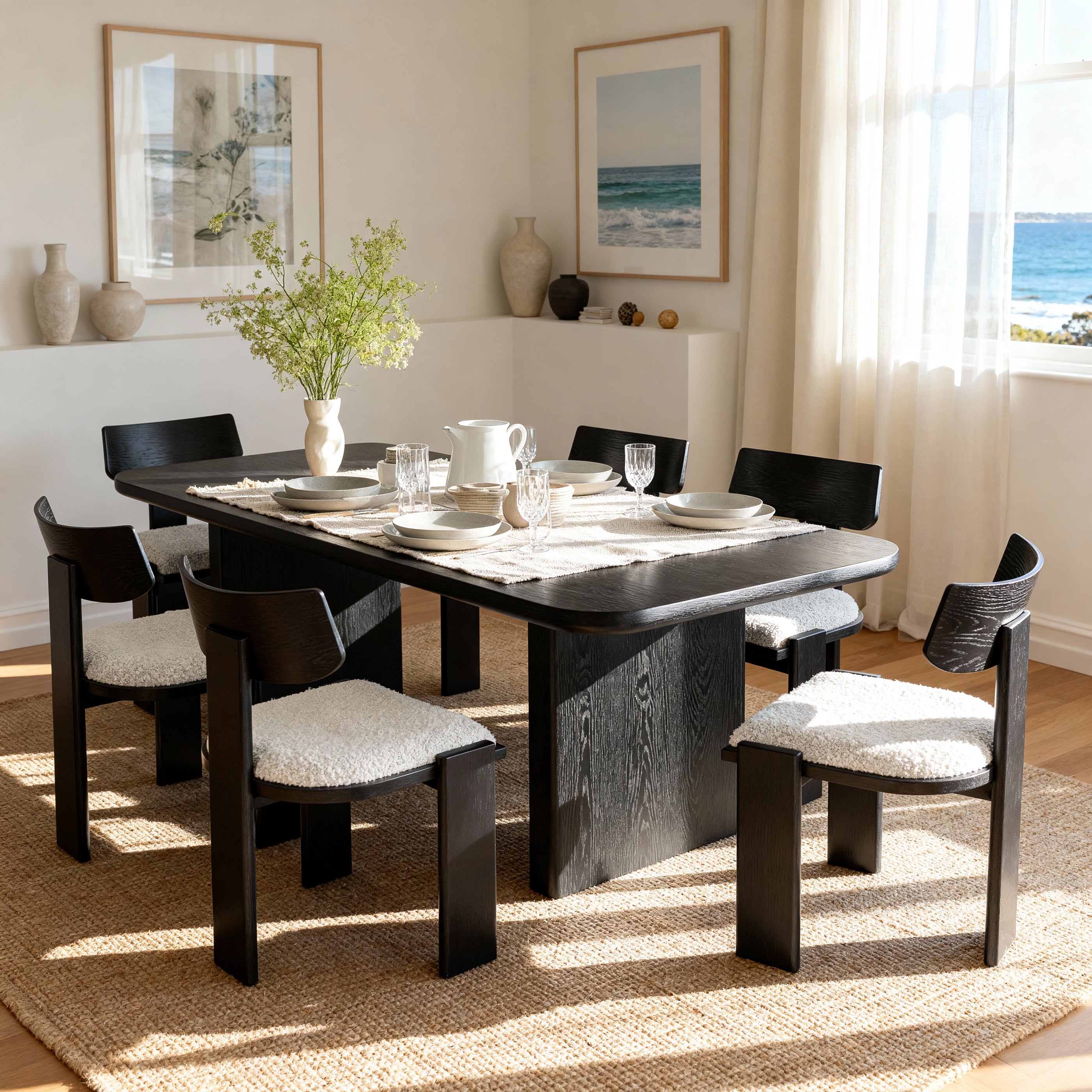 Dining room with a black dining table and chairs, set for a meal.

