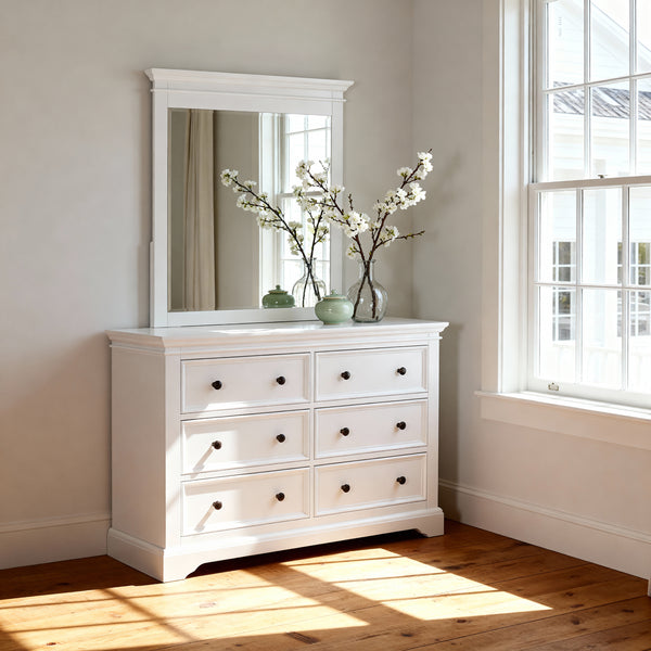 London Pine Mirror hung above a matching chest topped with blossom stems, in a sunlit corner