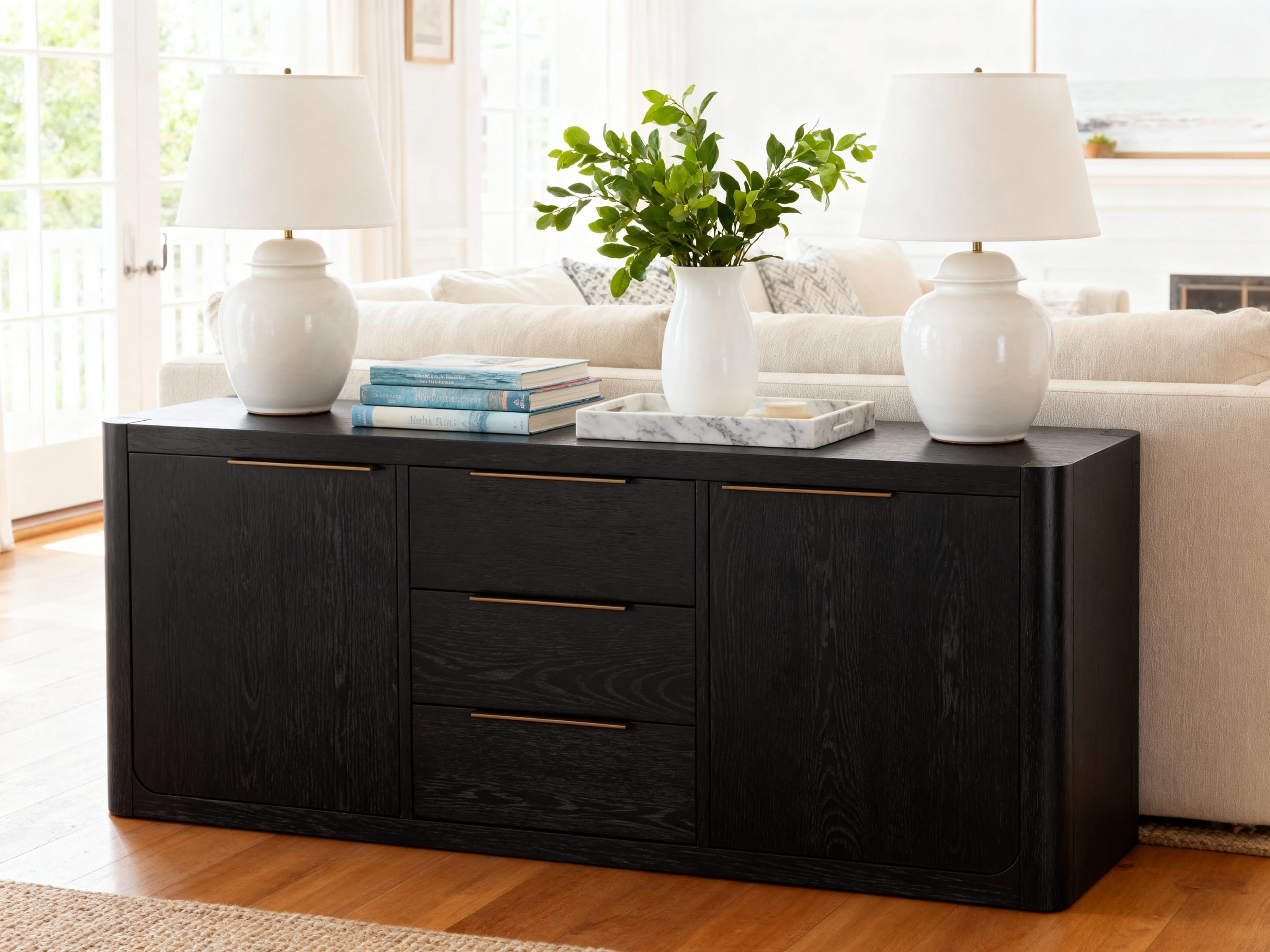 Black sideboard with gold handles in a living room setting

