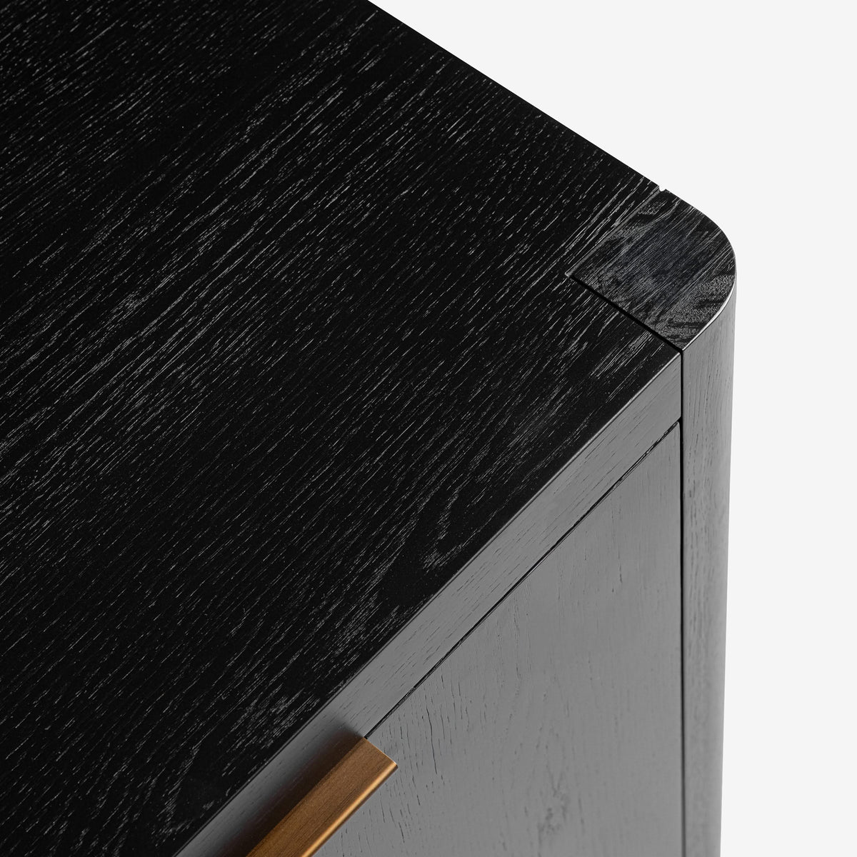Close-up of a black marble countertop with a gray cabinet and gold handle.

