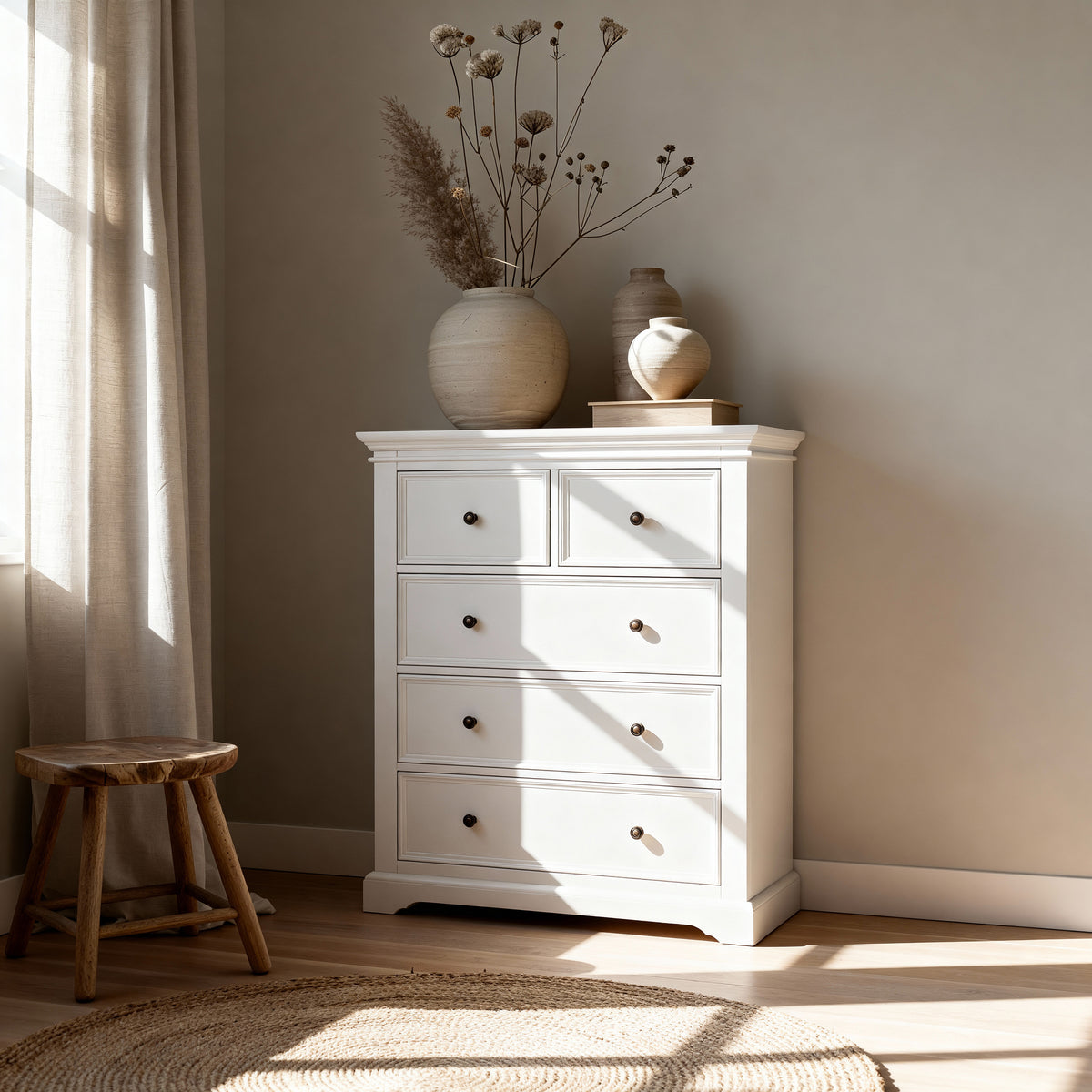 London Pine 5 Drawer Tallboy topped with dried blooms in stoneware vases, beside a timber stool on a jute rug