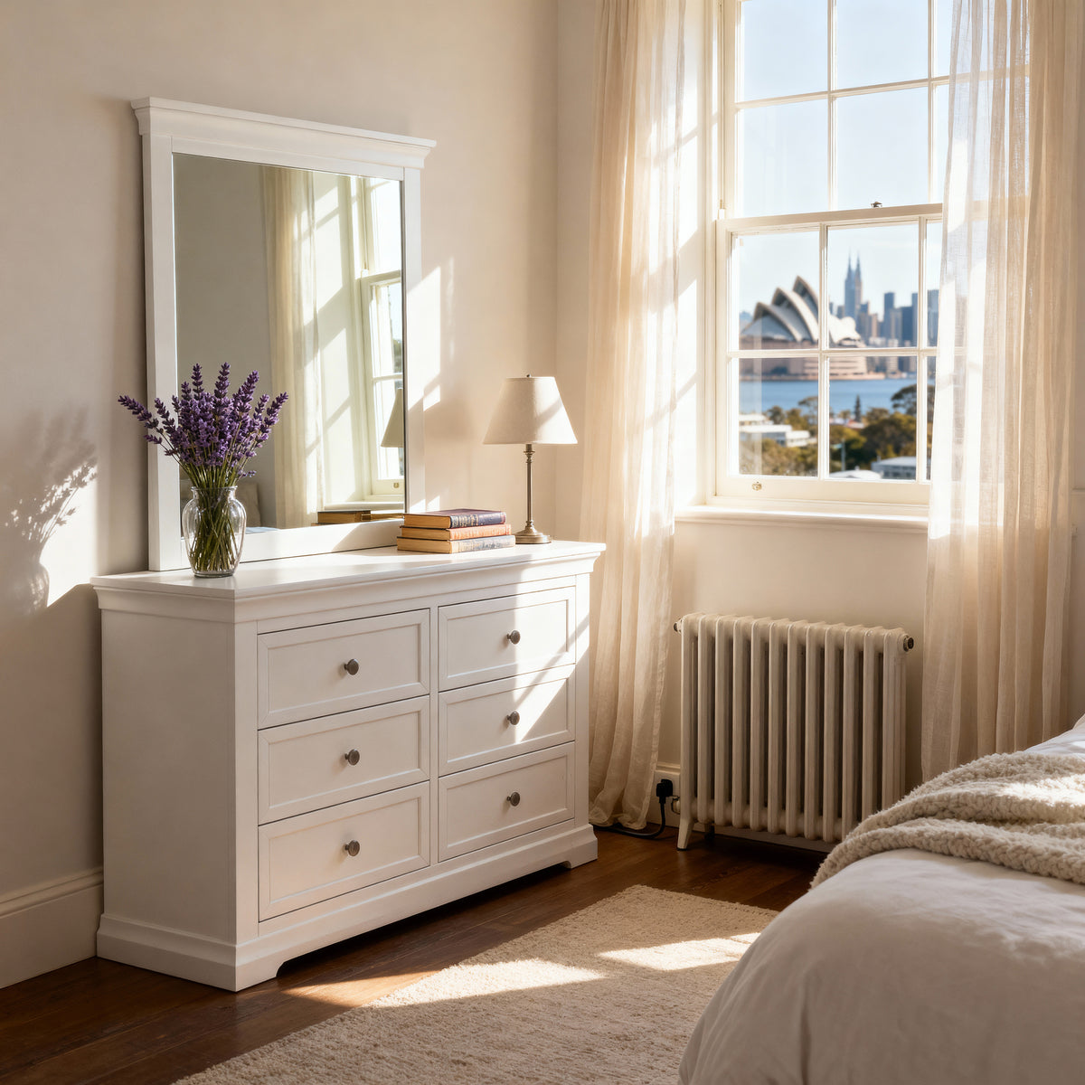 White dresser with mirror in a bedroom with large window and cityscape view

