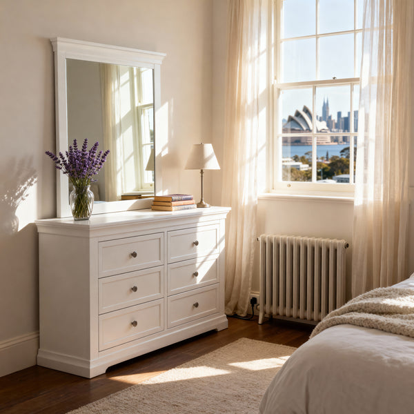 White dresser with mirror in a bedroom with large window and cityscape view


