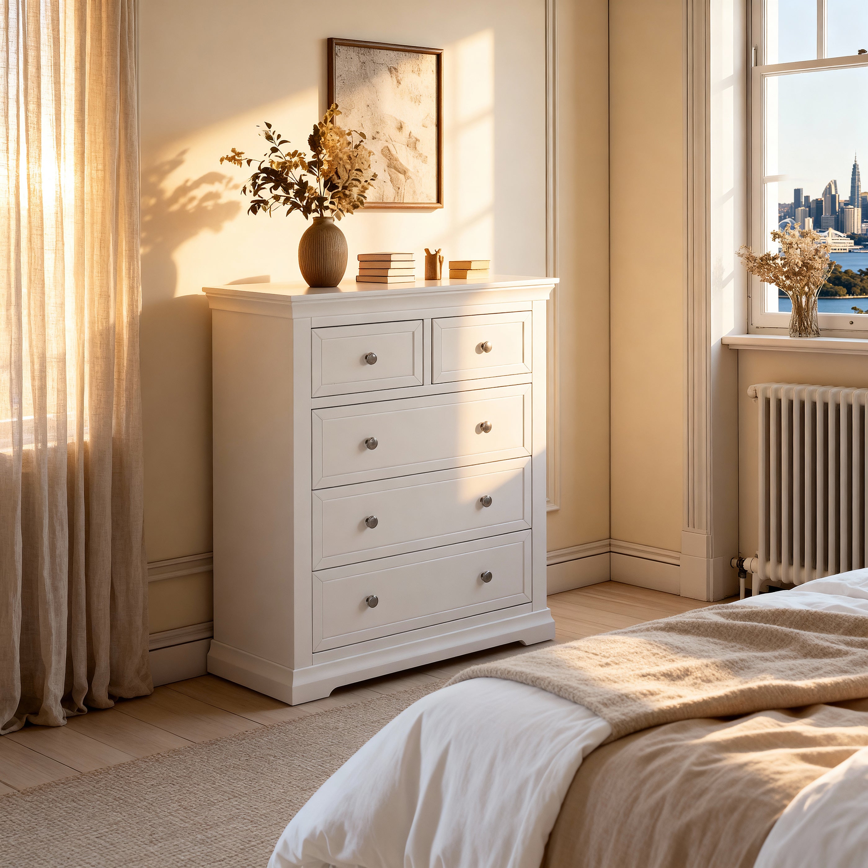 White dresser in a bedroom with a bed and window in the background

