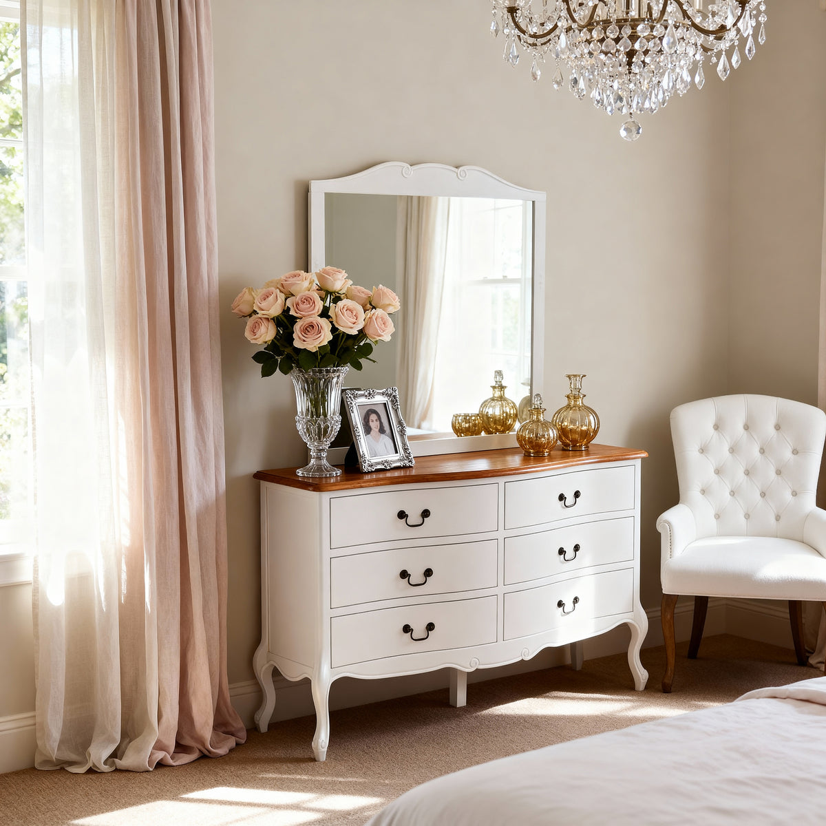 Newcastle Acacia 6 Drawer Chest hung above a matching chest, topped with roses and gold vases below a crystal chandelier