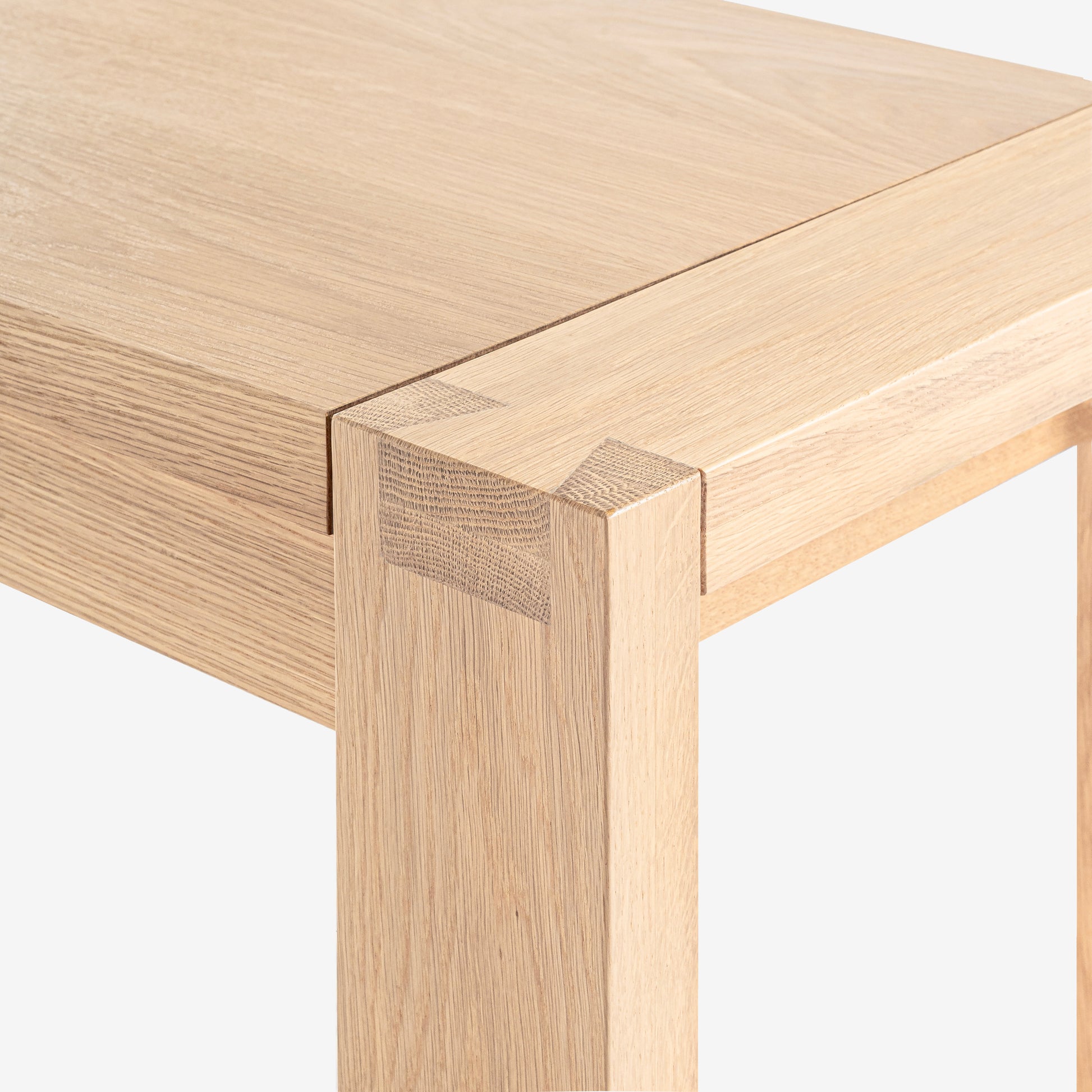 Close-up of a wooden table corner with a white background

