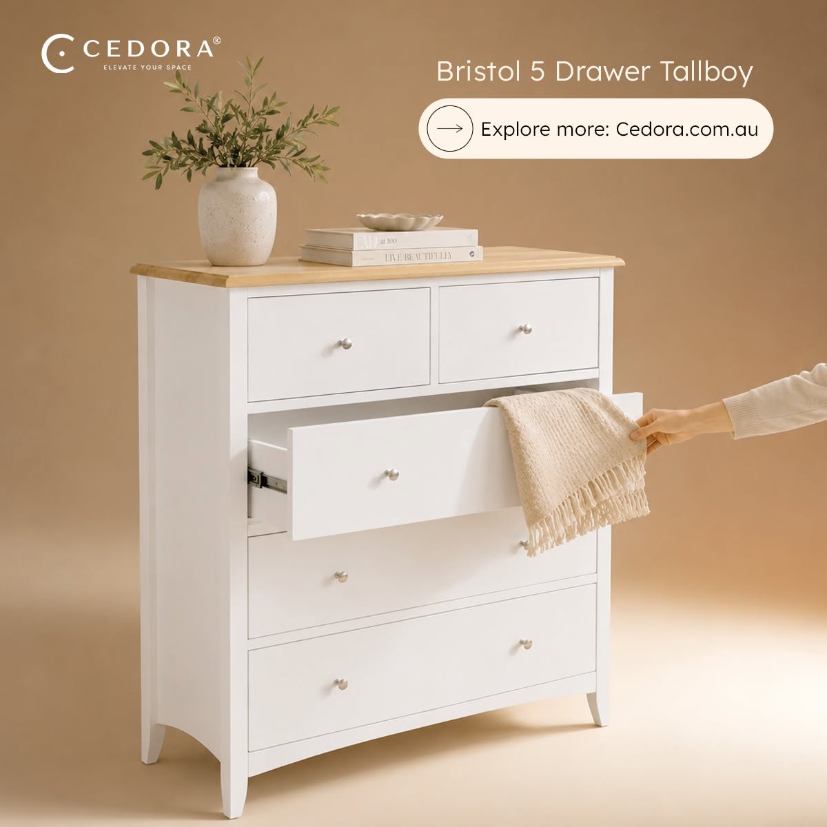 Bristol Pine 5 Drawer Tallboy with a hand pulling open a middle drawer to reveal a folded throw