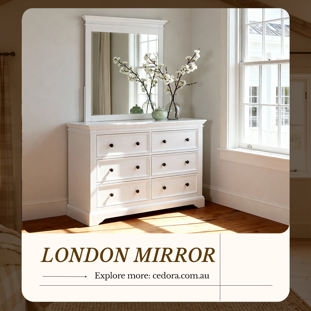 London Pine Mirror hung above a matching white six drawer chest with blossom stems in a sunlit bedroom, in a Cedora advert
