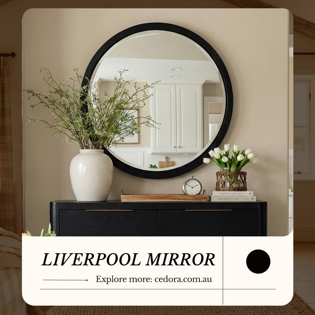 Liverpool Pine Mirror - Black hung above a dark sideboard with a vase of blossom and white tulips, in a Cedora advert
