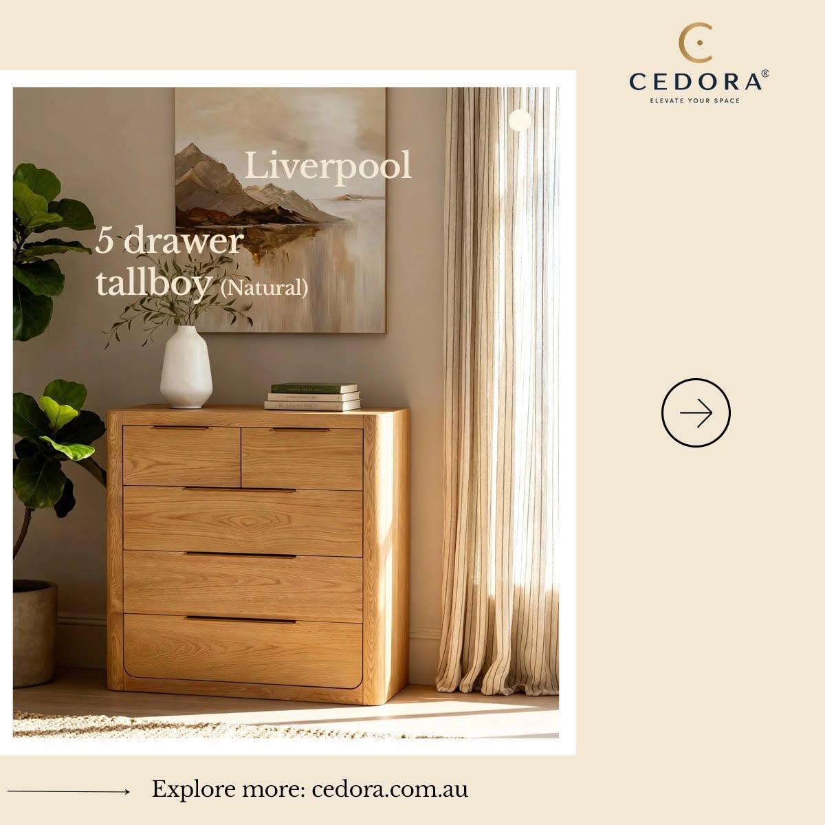 Liverpool Pine 5 Drawer Tallboy - Natural in a sunlit corner below framed landscape art beside a potted plant